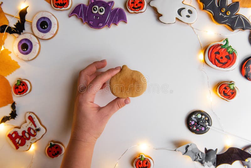 Step by step instructions on how to draw an orange pumpkin shaped gingerbread cookie using icing. Step 1, in the hand lies shape pumpkin of ginger dough. Halloween sweets on white isolated background. Step by step instructions on how to draw an orange pumpkin shaped gingerbread cookie using icing. Step 1, in the hand lies shape pumpkin of ginger dough. Halloween sweets on white isolated background