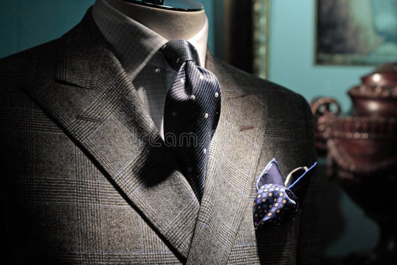 Close-up of a grey checkered jacket with white checkered shirt, dark blue tie and handkerchief. Close-up of a grey checkered jacket with white checkered shirt, dark blue tie and handkerchief