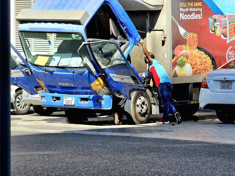 Μπλε φορτηγό μεταφοράς με κατεστραμμένο μπροστινό μέρος, στο οποίο παρευρέθηκε ένας εργάτης σταθμευμένος σε ένα δρόμο. στοκ εικόνες με δικαίωμα ελεύθερης χρήσης