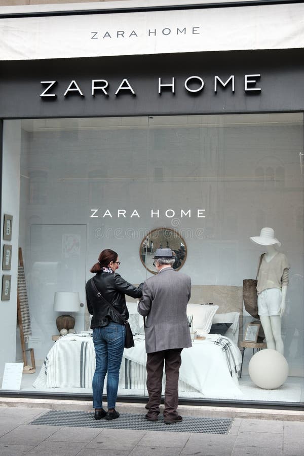 Bologna, Italy, 1 May 2017 - an old man and a woman look at the showcase of the Zara Home furnishing store in Bologna. Bologna, Italy, 1 May 2017 - an old man and a woman look at the showcase of the Zara Home furnishing store in Bologna.