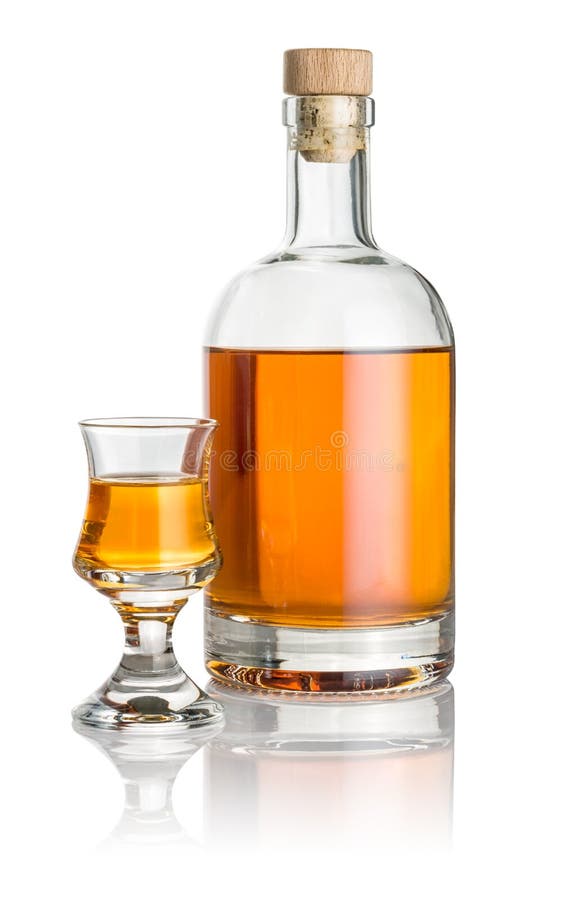 Μπουκάλι και schnapps γυαλί που γεμίζουν με το ηλέκτρινο υγρό στοκ φωτογραφία με δικαίωμα ελεύθερης χρήσης