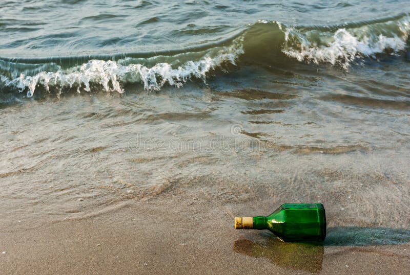 μπουκάλι μηνύματος στην παραλία σε κύματα στοκ εικόνες με δικαίωμα ελεύθερης χρήσης