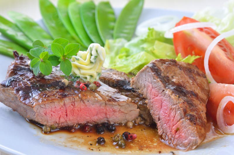 Medium grilled beef steak with sugar peas and side salad. Medium grilled beef steak with sugar peas and side salad