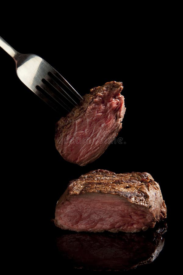 Medium rare beef steak on black background. Medium rare beef steak on black background.