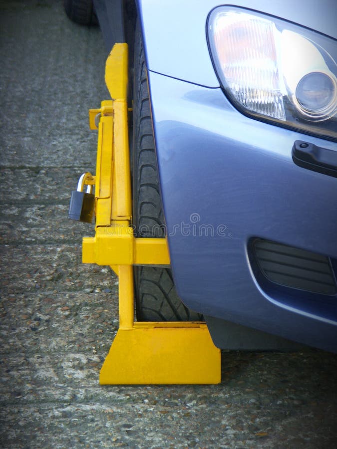 Wheel Clamp on illegally parked vehicle. Wheel Clamp on illegally parked vehicle