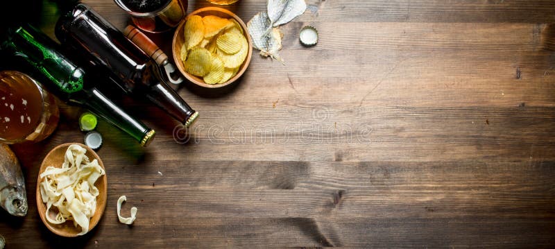 Μπύρα με τα διάφορα πρόχειρα φαγητά στο κύπελλο και τα αποξηραμένα ψάρια στοκ εικόνα με δικαίωμα ελεύθερης χρήσης Μπύρα με τα διάφορα πρόχειρα φαγητά στο κύπελλο και τα αποξηραμένα ψάρια στοκ εικόνα με δικαίωμα ελεύθερης χρήσης