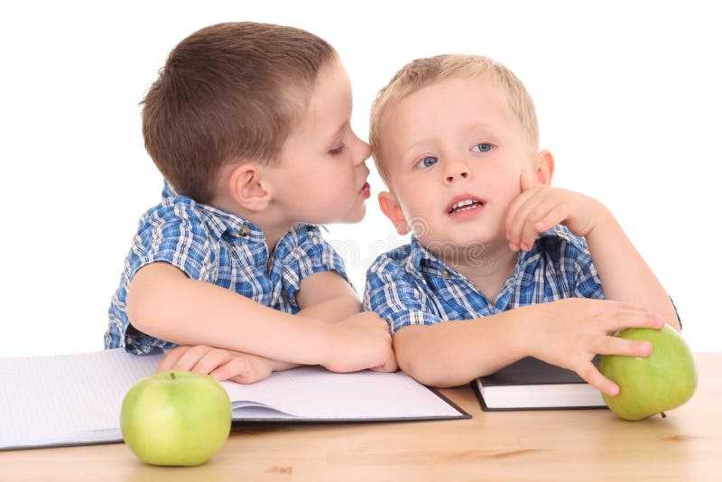 Two schoolboys at desk isolated on white. Two schoolboys at desk isolated on white