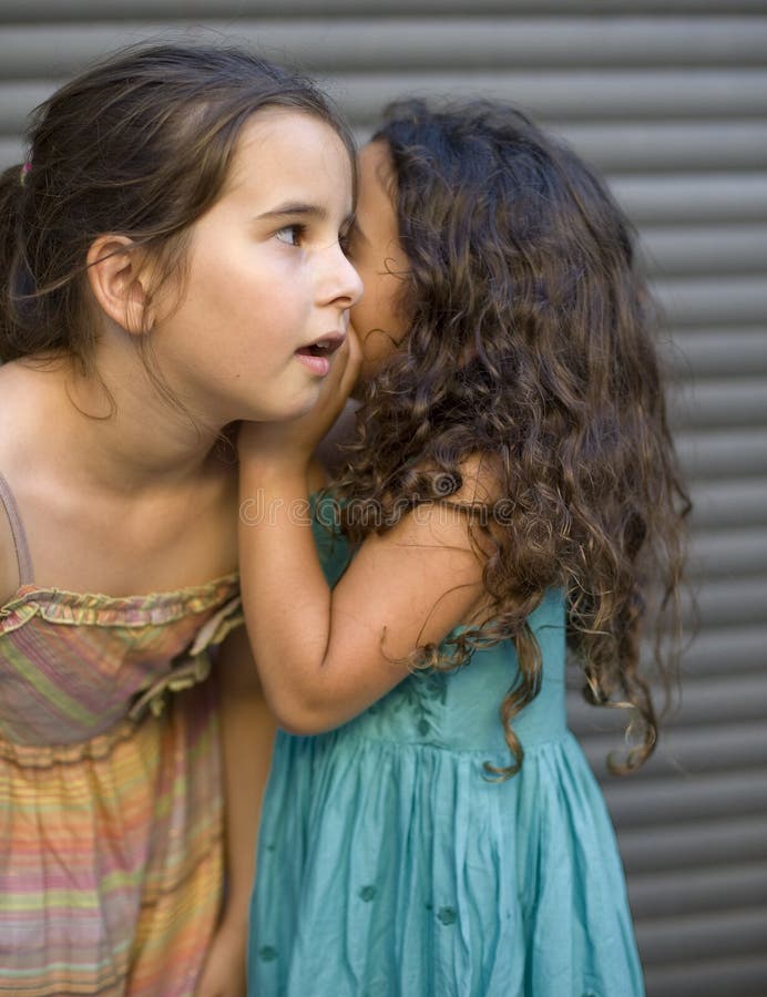 Two girls telling a secret. Two girls telling a secret