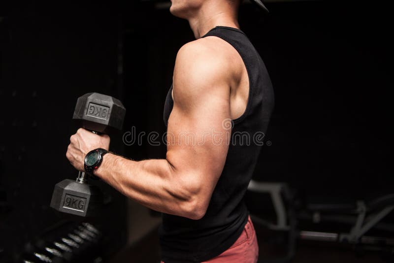 Μυϊκός τύπος bodybuilder που κάνει τις ασκήσεις με τον αλτήρα πέρα από το μαύρο υπόβαθρο στοκ εικόνες Μυϊκός τύπος bodybuilder που κάνει τις ασκήσεις με τον αλτήρα πέρα από το μαύρο υπόβαθρο στοκ εικόνες
