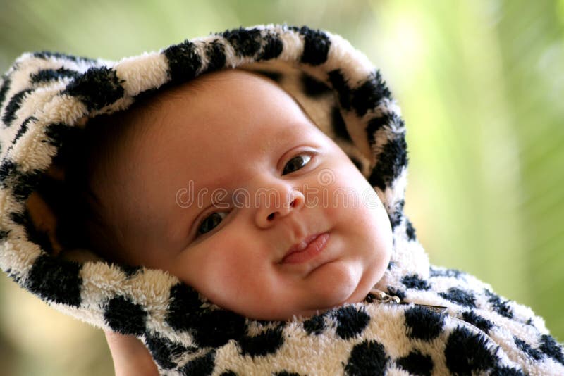 Image of a happy baby in a fancy dress with hood soft focus shallow DOF. Image of a happy baby in a fancy dress with hood soft focus shallow DOF