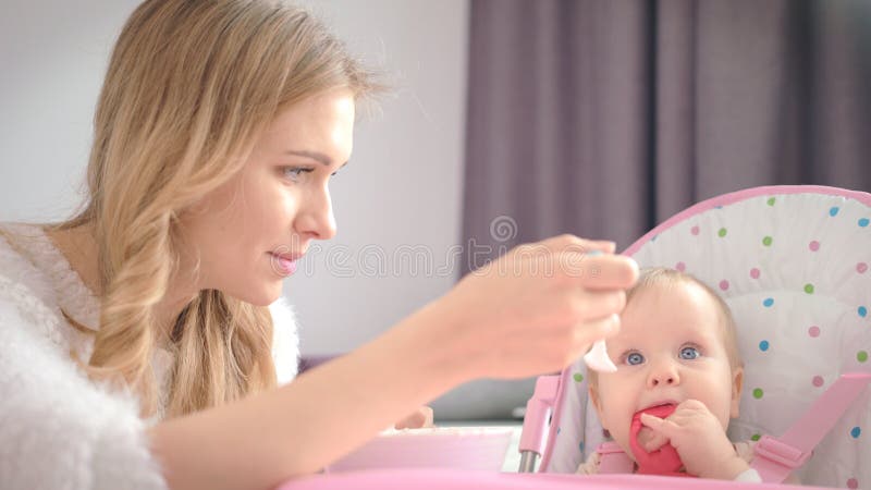 μωρό μασάει παιχνίδι και τρώει κεκαθαρμένο φαγητό. φαγητό μωρό φαγητό πρωινό. στοκ εικόνα με δικαίωμα ελεύθερης χρήσης