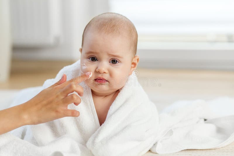 Μωρό με αβέβαιη έκφραση κατά τη ρουτίνα skincare στοκ φωτογραφία με δικαίωμα ελεύθερης χρήσης