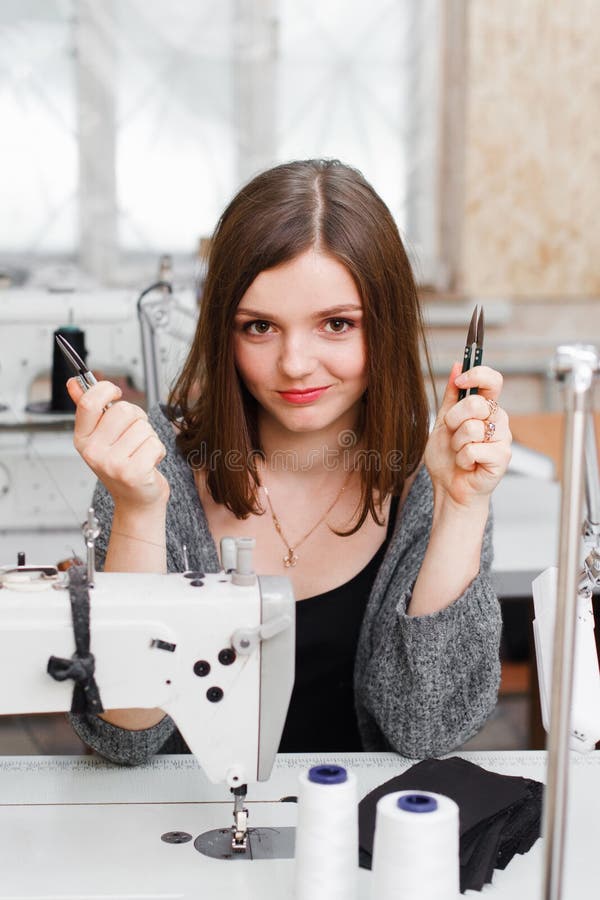Νέα seamstress χαμόγελου τοποθέτηση με το ψαλίδι στοκ φωτογραφίες Νέα seamstress χαμόγελου τοποθέτηση με το ψαλίδι στοκ φωτογραφίες