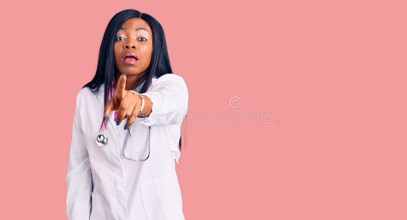 Young african american woman wearing doctor stethoscope pointing displeased and frustrated to the camera, angry and furious with you. Young african american woman wearing doctor stethoscope pointing displeased and frustrated to the camera, angry and furious with you