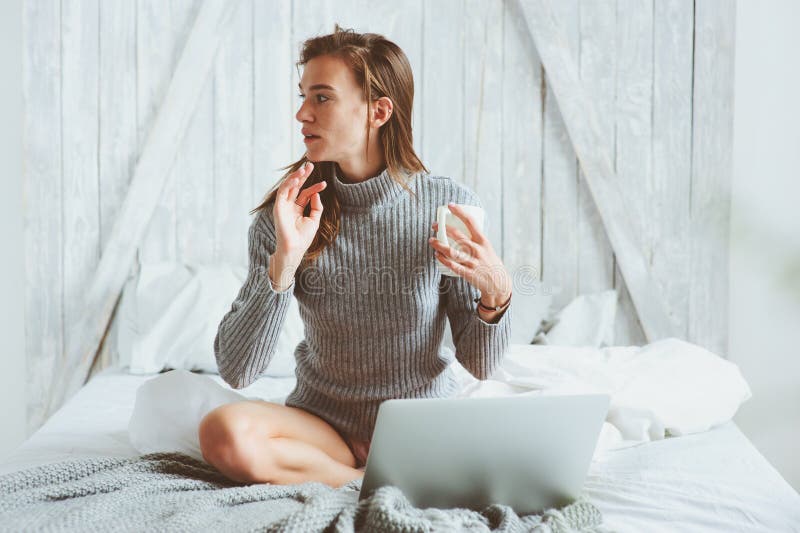 Νέα γυναίκα blogger ή επιχειρήσεων που εργάζεται στο σπίτι με τα κοινωνικά μέσα, καφές κατανάλωσης στα ξημερώματα στο κρεβάτι στοκ φωτογραφία με δικαίωμα ελεύθερης χρήσης Νέα γυναίκα blogger ή επιχειρήσεων που εργάζεται στο σπίτι με τα κοινωνικά μέσα, καφές κατανάλωσης στα ξημερώματα στο κρεβάτι στοκ φωτογραφία με δικαίωμα ελεύθερης χρήσης