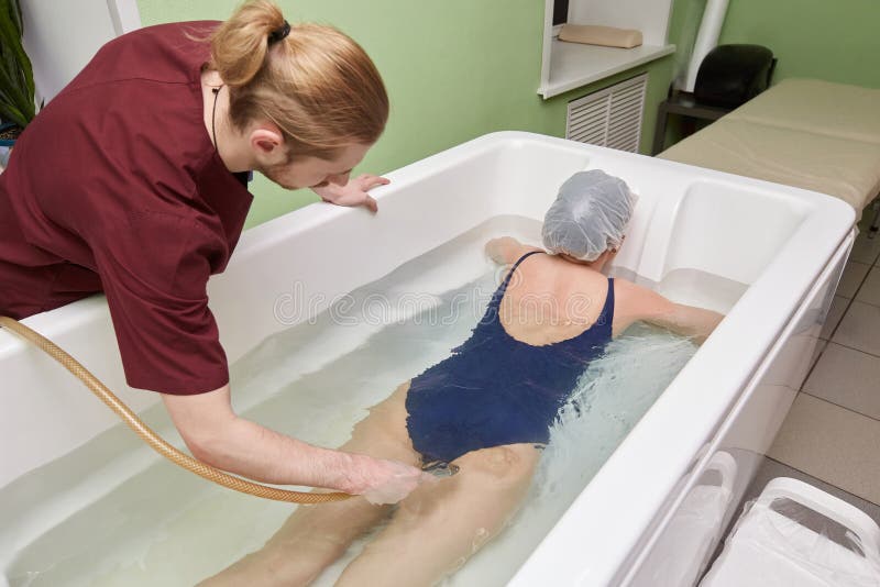 Νέα γυναίκα κατά τη διάρκεια του hydromassage beauty spa στο σαλόνι στοκ εικόνα με δικαίωμα ελεύθερης χρήσης Νέα γυναίκα κατά τη διάρκεια του hydromassage beauty spa στο σαλόνι στοκ εικόνα με δικαίωμα ελεύθερης χρήσης