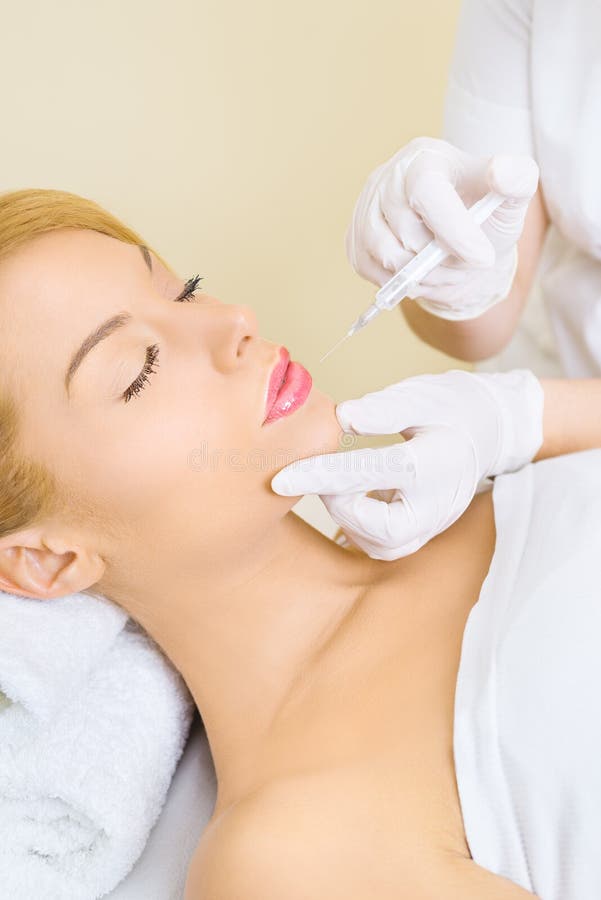 Νέα γυναίκα που λαμβάνει botox την έγχυση στα χείλια στοκ φωτογραφία με δικαίωμα ελεύθερης χρήσης Νέα γυναίκα που λαμβάνει botox την έγχυση στα χείλια στοκ φωτογραφία με δικαίωμα ελεύθερης χρήσης