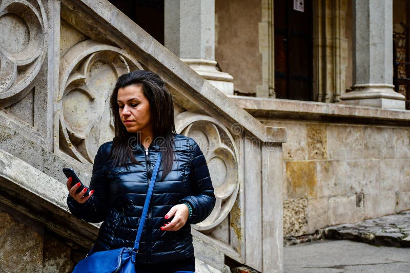 Νέα γυναίκα που χρησιμοποιεί ένα smartphone σε Corvin Castle, Ρουμανία στοκ φωτογραφίες Νέα γυναίκα που χρησιμοποιεί ένα smartphone σε Corvin Castle, Ρουμανία στοκ φωτογραφίες