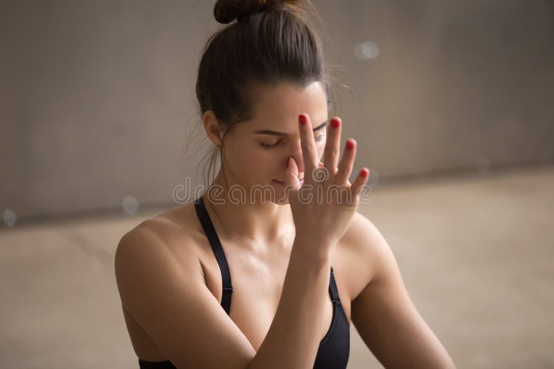 Νέα ελκυστική γυναίκα που κάνει το pranayama shodhana nadi, γκρίζο στήριγμα στοκ φωτογραφίες με δικαίωμα ελεύθερης χρήσης Νέα ελκυστική γυναίκα που κάνει το pranayama shodhana nadi, γκρίζο στήριγμα στοκ φωτογραφίες με δικαίωμα ελεύθερης χρήσης