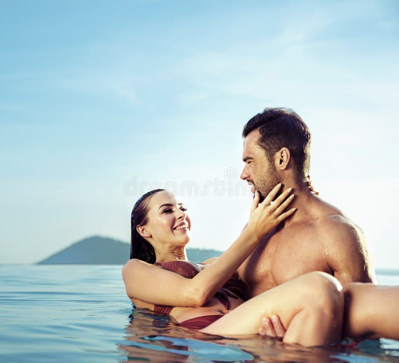 Νέα, ελκυστική χαλάρωση ζευγών σε μια θερμή, τροπική λίμνη στοκ εικόνα με δικαίωμα ελεύθερης χρήσης