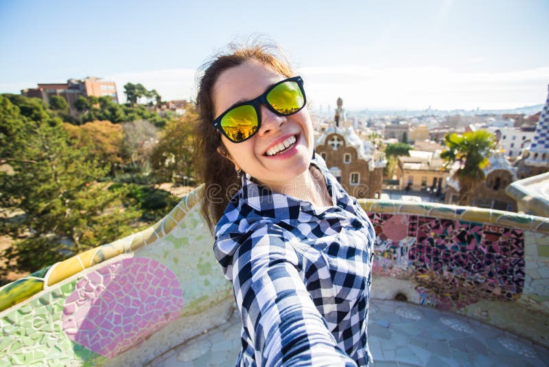 Νέα ευτυχής γυναίκα που κάνει selfie το πορτρέτο με το smartphone στο πάρκο Guell, Βαρκελώνη, Ισπανία Όμορφο κορίτσι που εξετάζει στοκ φωτογραφία με δικαίωμα ελεύθερης χρήσης Νέα ευτυχής γυναίκα που κάνει selfie το πορτρέτο με το smartphone στο πάρκο Guell, Βαρκελώνη, Ισπανία Όμορφο κορίτσι που εξετάζει στοκ φωτογραφία με δικαίωμα ελεύθερης χρήσης