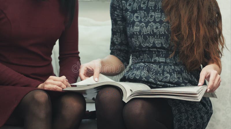 Νέα θηλυκά χέρια που κτυπούν μέσω μιας συνεδρίασης περιοδικών μόδας σε έναν καναπέ απόθεμα βίντεο