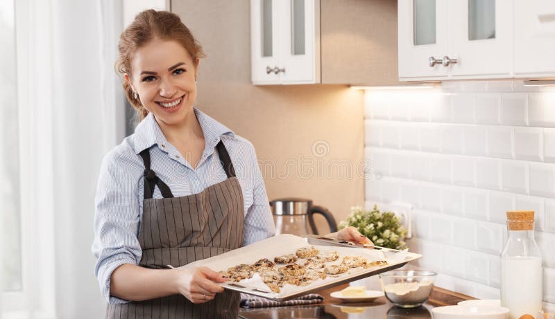 Νέα μπισκότα ψησίματος γυναικών στο σπίτι στην κουζίνα