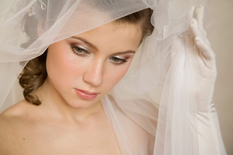 Close-up portret of young bride with the wail in her hand. Close-up portret of young bride with the wail in her hand