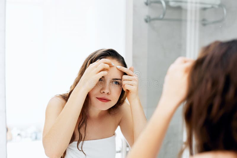 Νέα σπυράκια κοιτάγματος και συμπιέσεων γυναικών σε ένα πρόσωπο r Πρόβλημα με το κορίτσι δερμάτων, ακμή στο μέτωπο _ στοκ εικόνα με δικαίωμα ελεύθερης χρήσης Νέα σπυράκια κοιτάγματος και συμπιέσεων γυναικών σε ένα πρόσωπο r Πρόβλημα με το κορίτσι δερμάτων, ακμή στο μέτωπο _ στοκ εικόνα με δικαίωμα ελεύθερης χρήσης