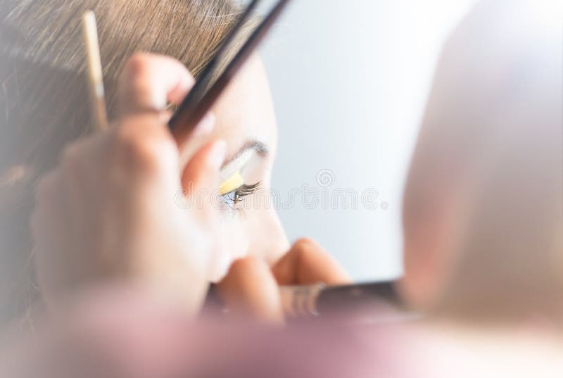 Νέα όμορφη γυναίκα που παίρνει τη σύνθεση με τη βούρτσα. στοκ εικόνες