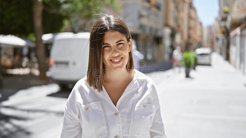 νέα όμορφη ισπανόφωνη γυναίκα που στέκεται χαμογελώντας στην πόλη στοκ εικόνες
