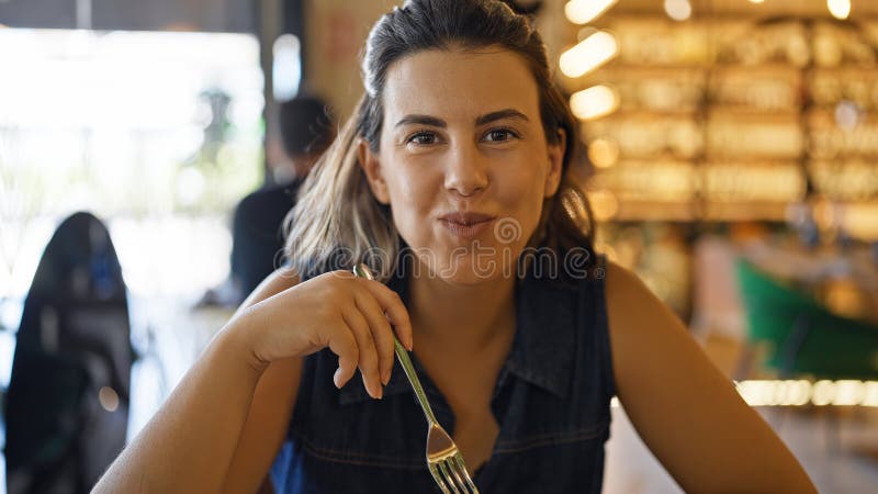 νέα όμορφη ισπανόφωνη γυναίκα που τρώει στο εστιατόριο στοκ φωτογραφία
