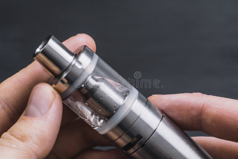 Νέο άτομο vaper με τη γενειάδα που ο μηχανικός νεαρός δικυκλιστής Ο τύπος καπνίζει ένα ηλεκτρονικό τσιγάρο με το φύσηγμα ενός ατμ στοκ εικόνες με δικαίωμα ελεύθερης χρήσης Νέο άτομο vaper με τη γενειάδα που ο μηχανικός νεαρός δικυκλιστής Ο τύπος καπνίζει ένα ηλεκτρονικό τσιγάρο με το φύσηγμα ενός ατμ στοκ εικόνες με δικαίωμα ελεύθερης χρήσης