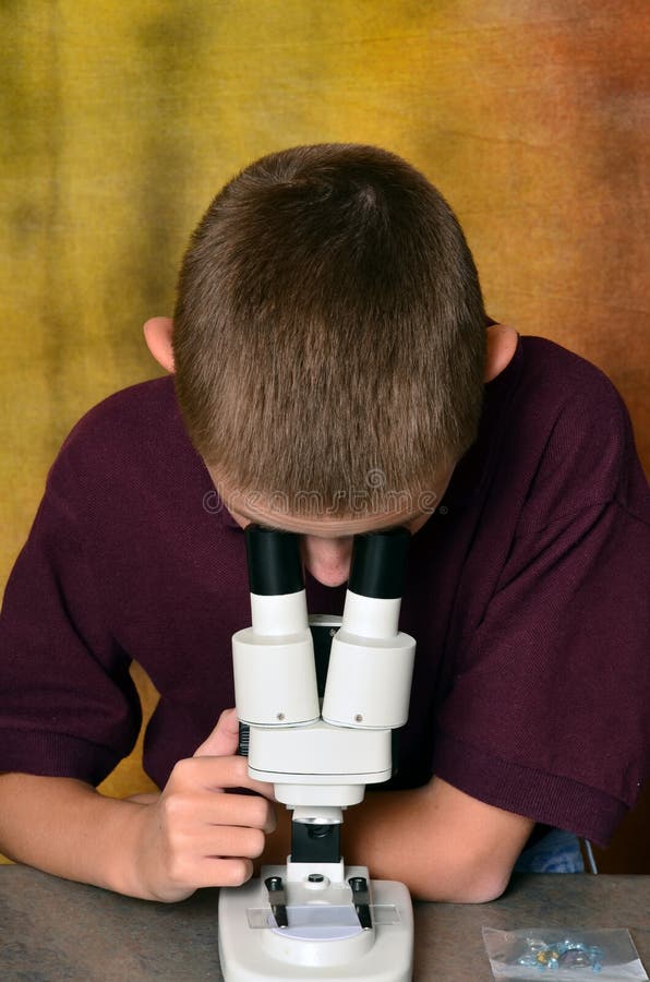Νέο αγόρι που χρησιμοποιεί ένα μικροσκόπιο