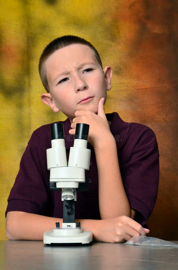 Νέο αγόρι που χρησιμοποιεί ένα μικροσκόπιο