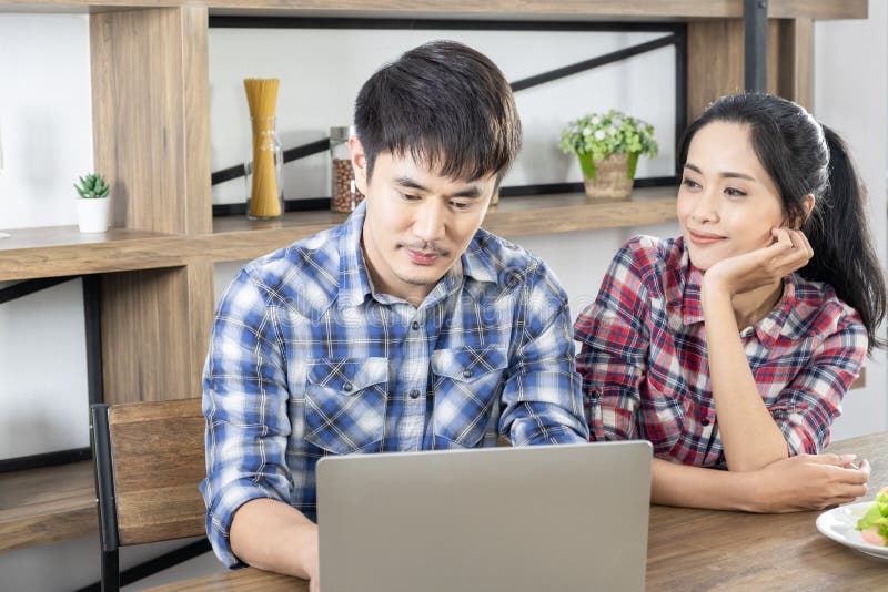 Νέο ασιατικό καλό lap-top προσοχής ζευγών για το σε απευθείας σύνδεση στο σπίτι γραφείο αγορών στοκ φωτογραφία Νέο ασιατικό καλό lap-top προσοχής ζευγών για το σε απευθείας σύνδεση στο σπίτι γραφείο αγορών στοκ φωτογραφία
