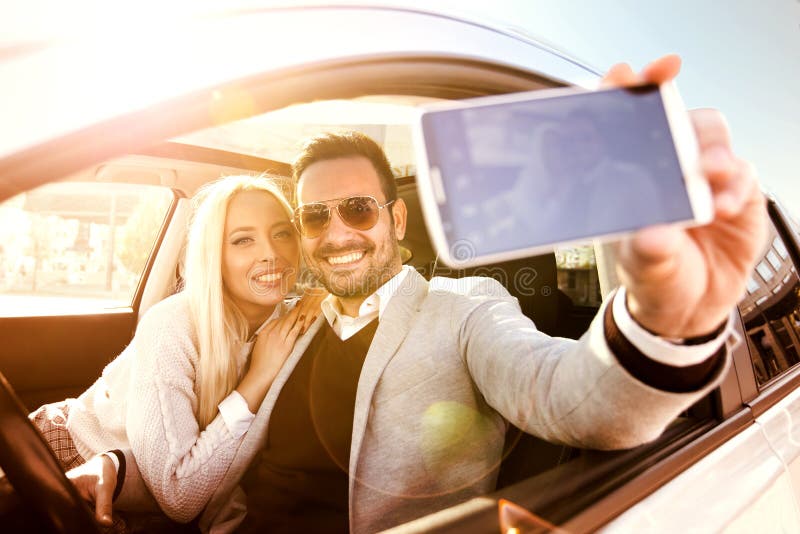 Νέο ζεύγος που παίρνει ένα selfie στο αυτοκίνητο στοκ φωτογραφία με δικαίωμα ελεύθερης χρήσης Νέο ζεύγος που παίρνει ένα selfie στο αυτοκίνητο στοκ φωτογραφία με δικαίωμα ελεύθερης χρήσης