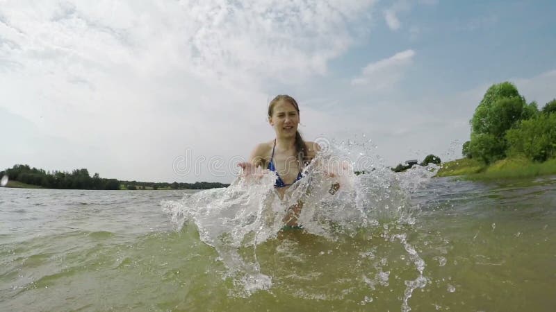 Νέο κορίτσι που καταβρέχει το νερό στη λίμνη