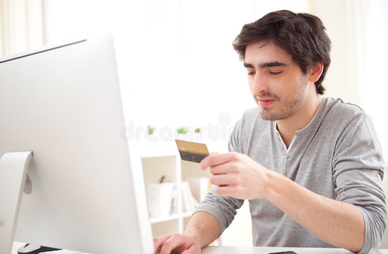 Νέο χαλαρωμένο άτομο που πληρώνει on-line με την πιστωτική κάρτα του στοκ εικόνες Νέο χαλαρωμένο άτομο που πληρώνει on-line με την πιστωτική κάρτα του στοκ εικόνες