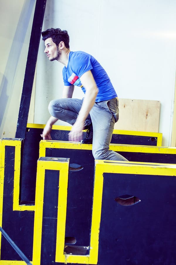 Νέο όμορφο άτομο που κάνει parkour στη γυμναστική μέσα, έννοια αθλητικών ανθρώπων τρόπου ζωής στοκ εικόνες