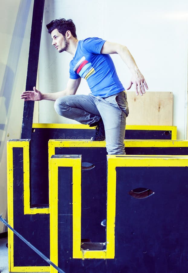 Νέο όμορφο άτομο που κάνει parkour στη γυμναστική μέσα, έννοια αθλητικών ανθρώπων τρόπου ζωής στοκ εικόνες