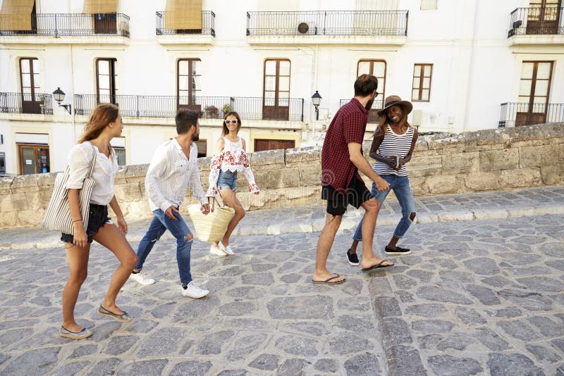 Νέοι ενήλικοι φίλοι στις διακοπές που περπατούν σε Ibiza, Ισπανία στοκ εικόνες Νέοι ενήλικοι φίλοι στις διακοπές που περπατούν σε Ibiza, Ισπανία στοκ εικόνες