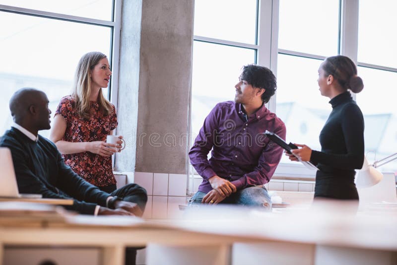 Team young professionals having casual discussion in office. Executives having friendly discussion during break. Team young professionals having casual discussion in office. Executives having friendly discussion during break.