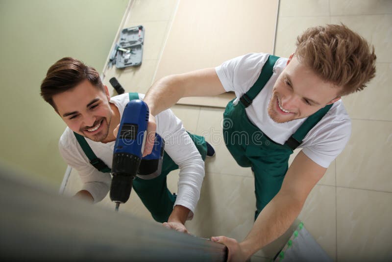 Νέοι εργαζόμενοι που εγκαθιστούν τον ξηρό τοίχο στο εσωτερικό Υπηρεσία εγχώριας επισκευής στοκ εικόνες