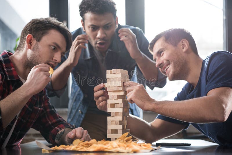 Νέοι που παίζουν το παιχνίδι jenga στοκ φωτογραφία με δικαίωμα ελεύθερης χρήσης Νέοι που παίζουν το παιχνίδι jenga στοκ φωτογραφία με δικαίωμα ελεύθερης χρήσης
