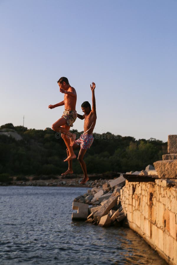 Νέοι τύποι που όπως για να πηδήσει στη θάλασσα στοκ φωτογραφία με δικαίωμα ελεύθερης χρήσης Νέοι τύποι που όπως για να πηδήσει στη θάλασσα στοκ φωτογραφία με δικαίωμα ελεύθερης χρήσης