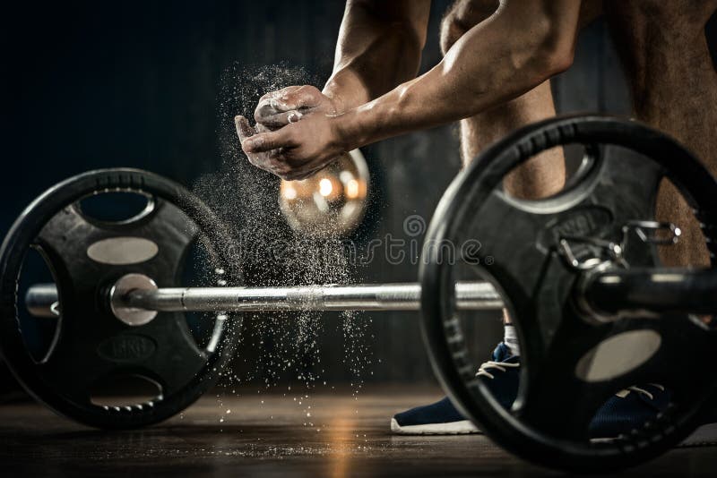 Sports background. Young athlete getting ready for weight lifting training. Powerlifter hand in talc preparing to bench press. Sports background. Young athlete getting ready for weight lifting training. Powerlifter hand in talc preparing to bench press