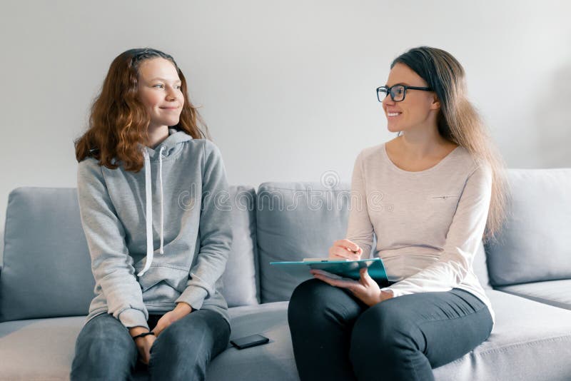 Νέος επαγγελματικός ψυχολόγος γυναικών που μιλά με το κορίτσι 14, εφήβων χρονών να καθίσει 15 στην αρχή στον καναπέ Πνευματικές υ