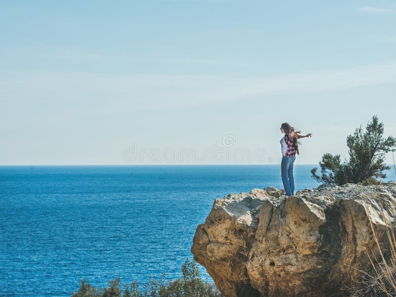 Νέος ευτυχής ταξιδιώτης κοριτσιών που στέκεται στο βράχο πέρα από τη θάλασσα, Τουρκία στοκ εικόνες με δικαίωμα ελεύθερης χρήσης Νέος ευτυχής ταξιδιώτης κοριτσιών που στέκεται στο βράχο πέρα από τη θάλασσα, Τουρκία στοκ εικόνες με δικαίωμα ελεύθερης χρήσης