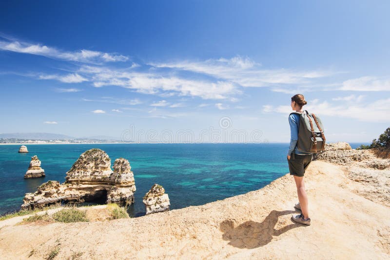 Νέος ταξιδιώτης γυναικών που εξετάζει τη θάλασσα στην πόλη του Λάγκος, περιοχή του Αλγκάρβε, της Πορτογαλίας Ταξίδι και ενεργός έ στοκ φωτογραφία με δικαίωμα ελεύθερης χρήσης Νέος ταξιδιώτης γυναικών που εξετάζει τη θάλασσα στην πόλη του Λάγκος, περιοχή του Αλγκάρβε, της Πορτογαλίας Ταξίδι και ενεργός έ στοκ φωτογραφία με δικαίωμα ελεύθερης χρήσης